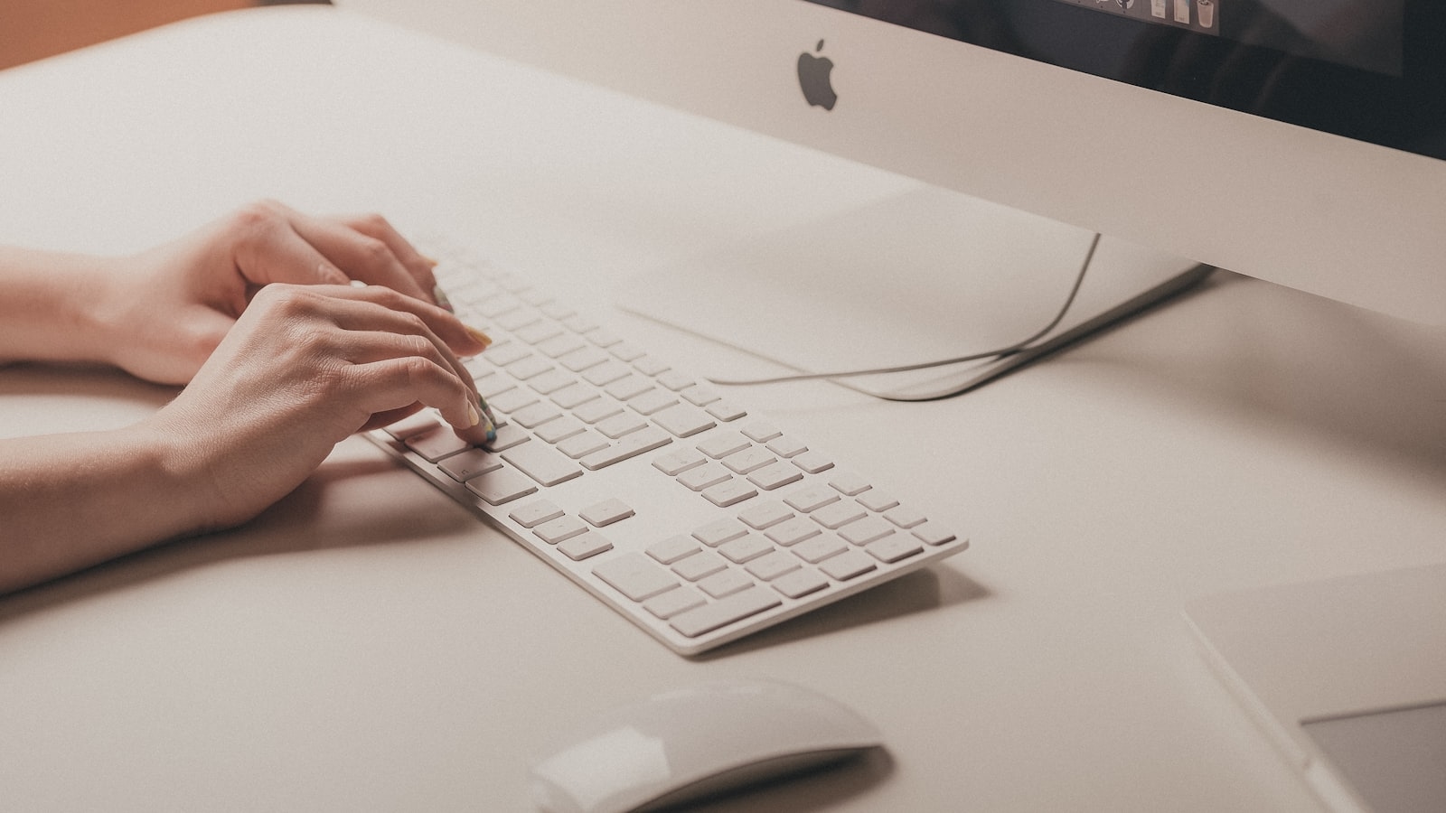 Person typing on apple keyboard